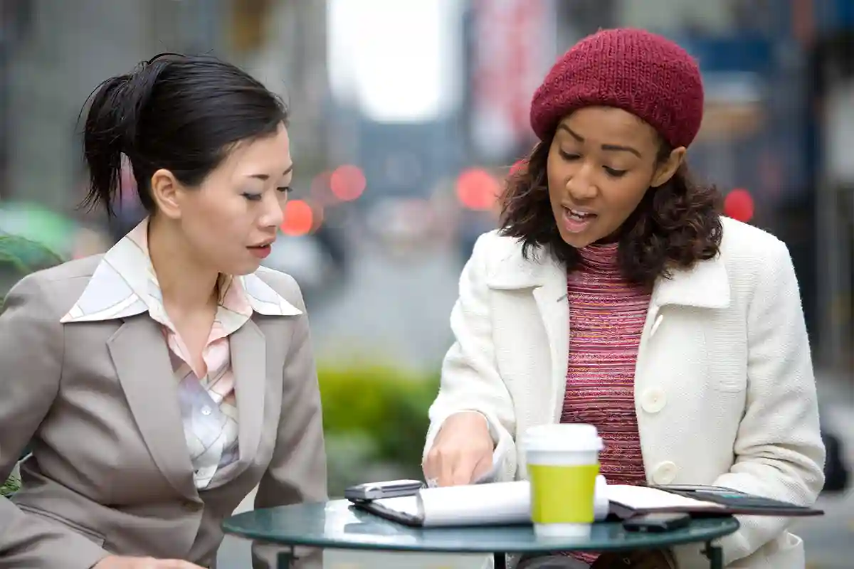 Two ladies over discussing over coffee